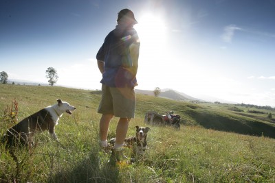 Farmer standing in paddock with dogs